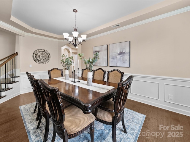 1190 Arges River Dr, Fort Mill, SC 29715 - dining area featuring a raised ceiling, a chandelier, dark wood-style floors, a decorative wall, and wainscoting