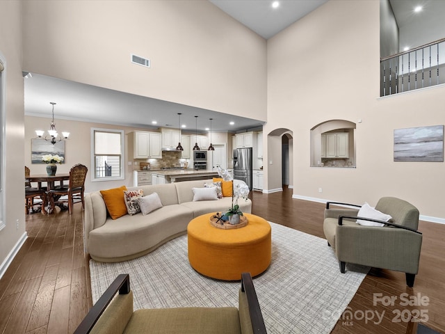 1190 Arges River Dr, Fort Mill, SC 29715 - living area with arched walkways, baseboards, a chandelier, dark wood finished floors, and a high ceiling