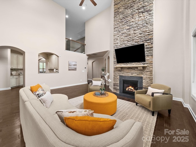 1190 Arges River Dr, Fort Mill, SC 29715 - living room featuring ceiling fan, dark wood finished floors, baseboards, a fireplace, and a high ceiling