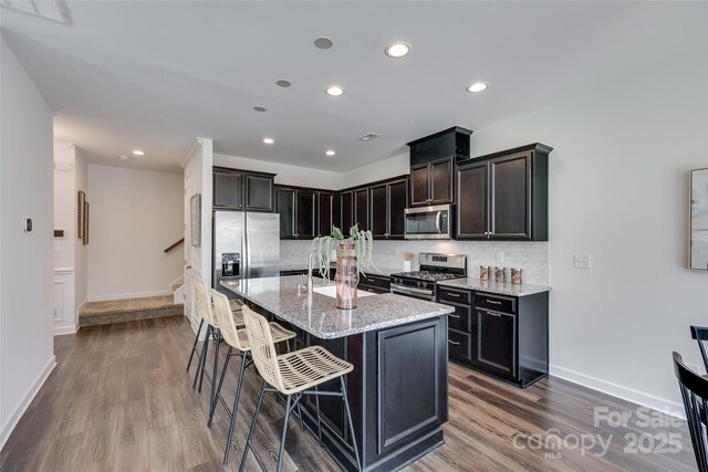 5836 Clan Maclaine Dr, Charlotte, NC 28278 - kitchen with stainless steel appliances, dark wood-type flooring, backsplash, light stone counters, and recessed lighting