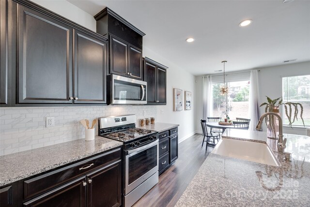 5836 Clan Maclaine Dr, Charlotte, NC 28278 - kitchen featuring stainless steel appliances, a sink, tasteful backsplash, dark wood-type flooring, and light stone countertops