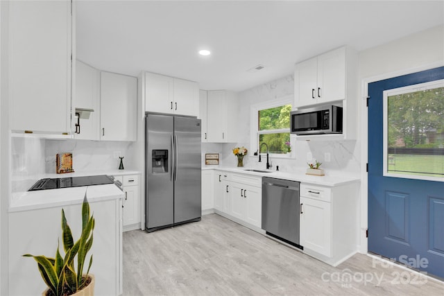 4108 Mellon Rd, Matthews, NC 28104 - kitchen featuring appliances with stainless steel finishes, a sink, light countertops, light wood-style flooring, and decorative backsplash