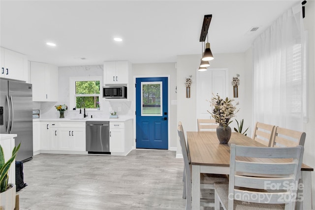 4108 Mellon Rd, Matthews, NC 28104 - kitchen with stainless steel appliances, light countertops, white cabinets, and recessed lighting