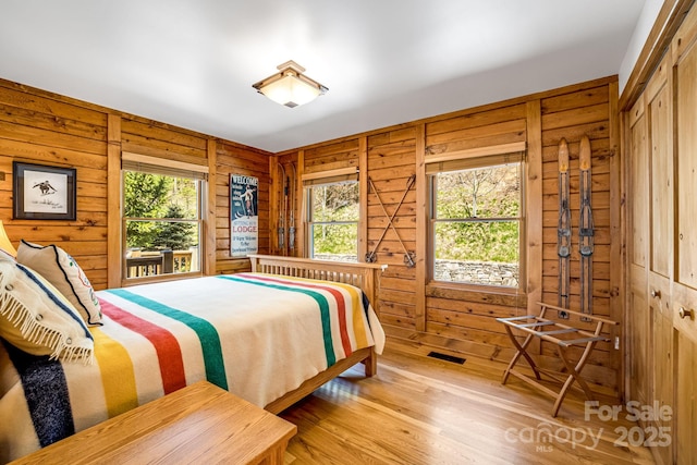 2399 El Miner Dr, Mars Hill, NC 28754 - bedroom with multiple windows, wood walls, wood finished floors, and a closet
