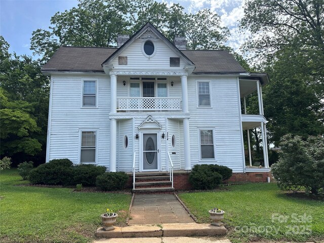 204 N Gaston St, Kings Mountain, NC 28086 - view of front of house with a balcony, a front lawn, and a chimney