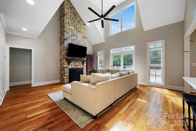 6409 Barkley Farm Rd, Huntersville, NC 28078 - living area featuring a stone fireplace, ceiling fan, light wood-type flooring, a towering ceiling, and baseboards
