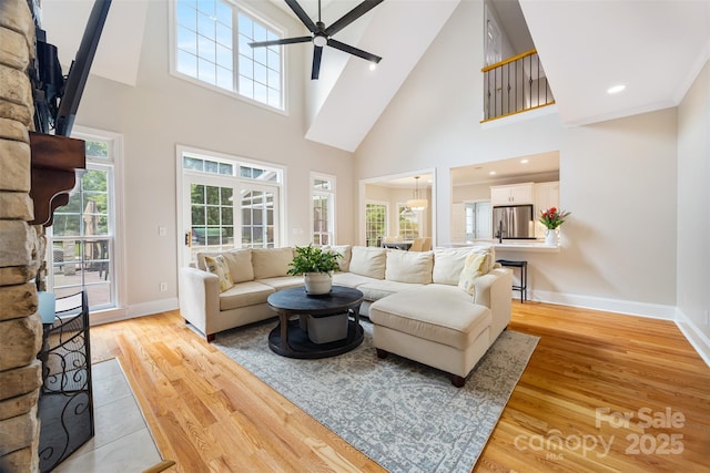 6409 Barkley Farm Rd, Huntersville, NC 28078 - living room with a high ceiling, a ceiling fan, light wood-style flooring, and baseboards