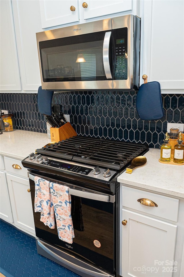 10100 Jack Nicklaus Dr, Lancaster, SC 29720 - kitchen with gas range oven, stainless steel microwave, white cabinetry, and tasteful backsplash