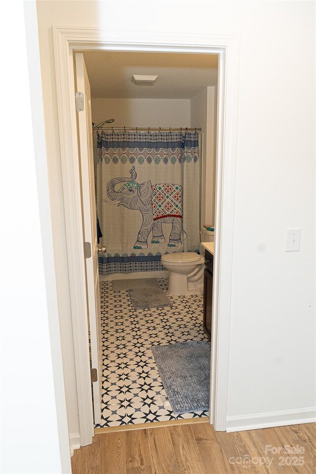 10100 Jack Nicklaus Dr, Lancaster, SC 29720 - bathroom with vanity, wood finished floors, toilet, and curtained shower