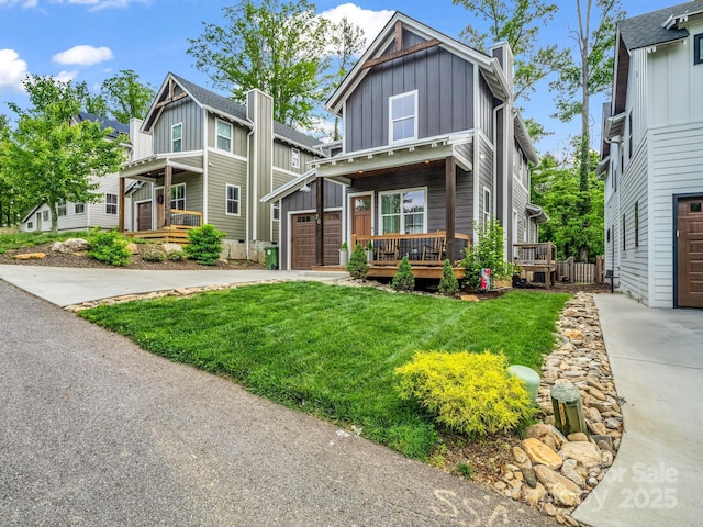 20 Phillip Ln, Arden, NC 28704 - view of front of home with board and batten siding, a garage, a front lawn, driveway, and a wooden deck