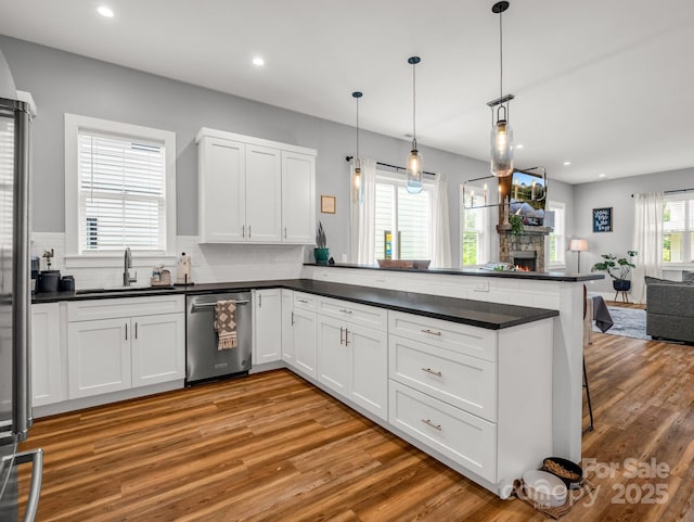20 Phillip Ln, Arden, NC 28704 - kitchen with dishwasher, a sink, dark countertops, open floor plan, and light wood-type flooring