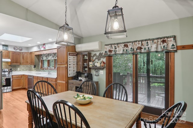 457 Shady Ridge Rd, Waynesville, NC 28785 - dining space with a skylight, a wall mounted air conditioner, plenty of natural light, light wood-style flooring, and lofted ceiling