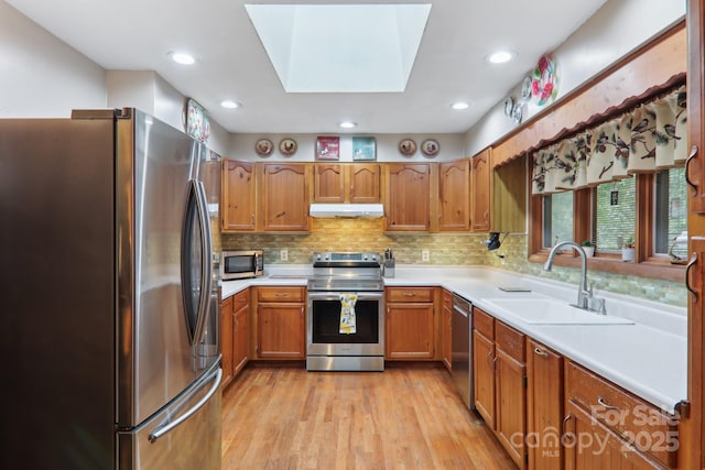 457 Shady Ridge Rd, Waynesville, NC 28785 - kitchen with appliances with stainless steel finishes, a sink, light wood finished floors, light countertops, and under cabinet range hood