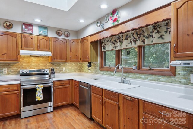 457 Shady Ridge Rd, Waynesville, NC 28785 - kitchen featuring stainless steel appliances, a sink, under cabinet range hood, light countertops, and light wood-type flooring