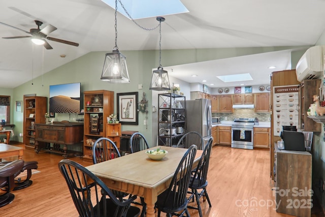 457 Shady Ridge Rd, Waynesville, NC 28785 - dining space featuring a skylight, lofted ceiling, light wood-type flooring, a wall unit AC, and ceiling fan