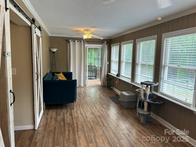 259 Oakland Heights Rd, Forest City, NC 28043 - sitting room with crown molding, a barn door, a ceiling fan, baseboards, and a textured ceiling