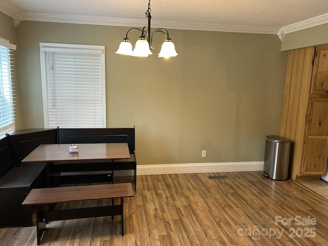 259 Oakland Heights Rd, Forest City, NC 28043 - dining area with ornamental molding, wood finished floors, a chandelier, and baseboards