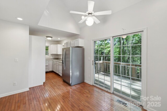 124 Hilltop Rd, Black Mountain, NC 28711 - kitchen featuring stainless steel fridge with ice dispenser, plenty of natural light, white cabinets, light wood-type flooring, and lofted ceiling