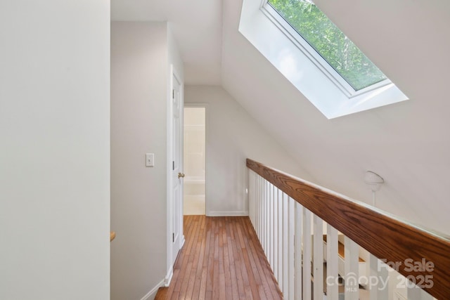 124 Hilltop Rd, Black Mountain, NC 28711 - corridor featuring a skylight, lofted ceiling, light wood-type flooring, and baseboards