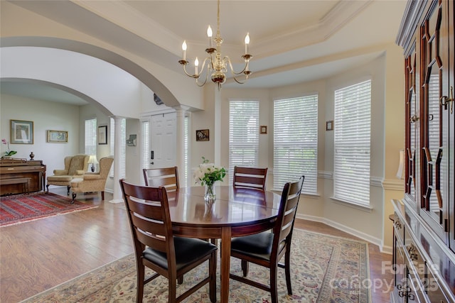 12125 Mountainside Ln, Charlotte, NC 28278 - dining space with arched walkways, ornate columns, plenty of natural light, wood finished floors, and ornamental molding