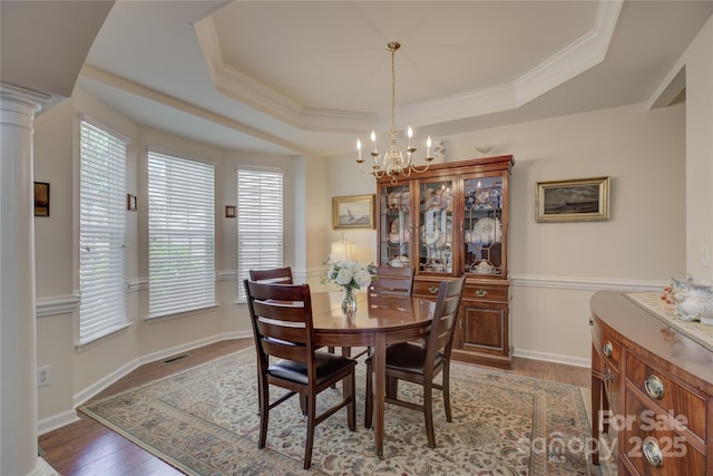 12125 Mountainside Ln, Charlotte, NC 28278 - dining room featuring a chandelier, wood finished floors, a tray ceiling, healthy amount of natural light, and crown molding