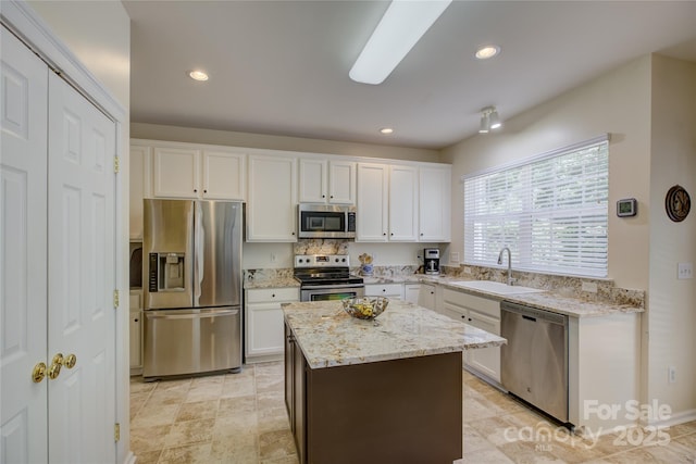 12125 Mountainside Ln, Charlotte, NC 28278 - kitchen with appliances with stainless steel finishes, a sink, white cabinets, light stone countertops, and recessed lighting