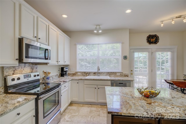 12125 Mountainside Ln, Charlotte, NC 28278 - kitchen with stainless steel appliances, a sink, white cabinets, light stone counters, and recessed lighting