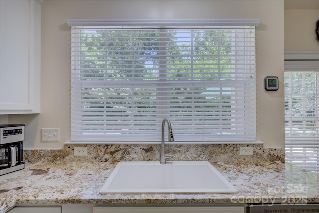 12125 Mountainside Ln, Charlotte, NC 28278 - kitchen view of a sink, dishwasher, white cabinets, and light stone countertops