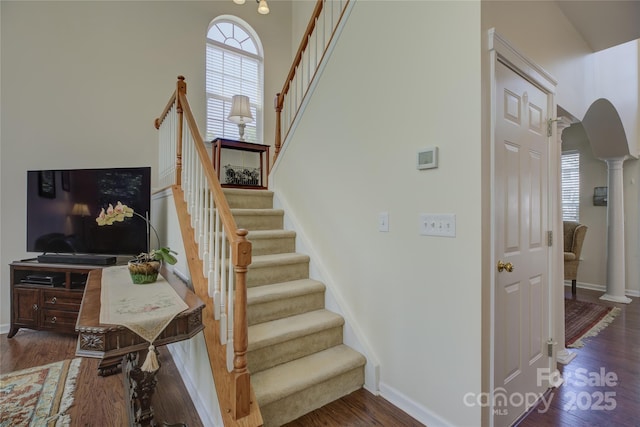 12125 Mountainside Ln, Charlotte, NC 28278 - stairs with arched walkways, decorative columns, wood finished floors, and baseboards