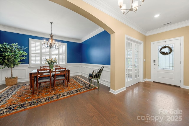 17028 River Race Dr, Huntersville, NC 28078 - foyer with a chandelier, crown molding, arched walkways, a wainscoted wall, and wood finished floors
