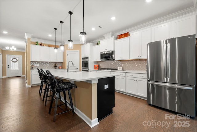 17028 River Race Dr, Huntersville, NC 28078 - kitchen featuring stainless steel appliances, crown molding, a sink, a kitchen island with sink, and decorative backsplash