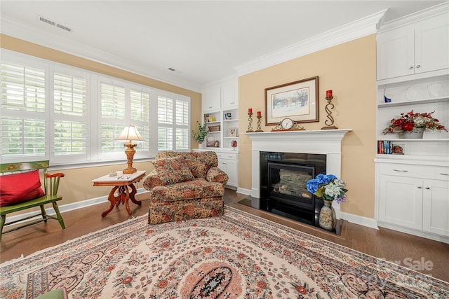 17028 River Race Dr, Huntersville, NC 28078 - living area featuring dark wood finished floors, crown molding, built in shelves, baseboards, and a glass covered fireplace