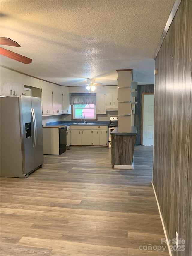 304 W Miller St, Jefferson, SC 29718 - kitchen with ceiling fan, stainless steel appliances, a textured ceiling, a sink, and wood walls
