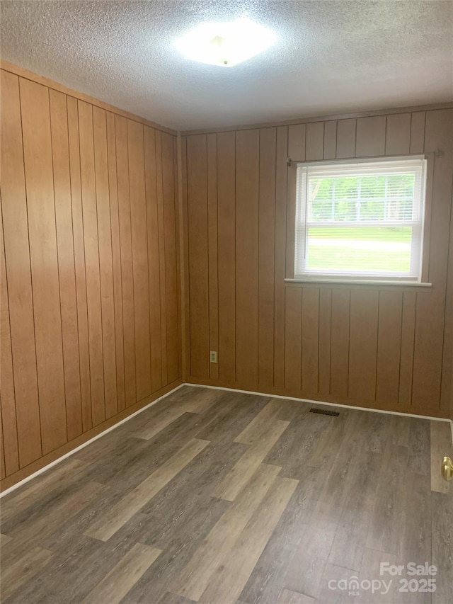 304 W Miller St, Jefferson, SC 29718 - empty room with wood finished floors, a textured ceiling, and wooden walls