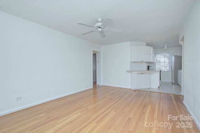 101 S Laurel Ave Unit 72A, Charlotte, NC 28207 - unfurnished living room with light wood-style floors, baseboards, and a ceiling fan