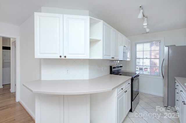 101 S Laurel Ave Unit 72A, Charlotte, NC 28207 - kitchen featuring range with electric stovetop, white microwave, freestanding refrigerator, and decorative backsplash