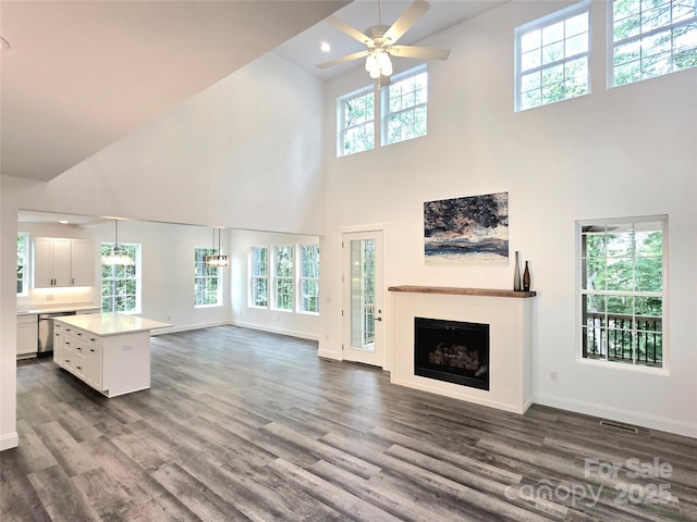 690 Settlers Trl, Mars Hill, NC 28754 - unfurnished living room with a high ceiling, a ceiling fan, dark wood-style floors, a fireplace, and baseboards