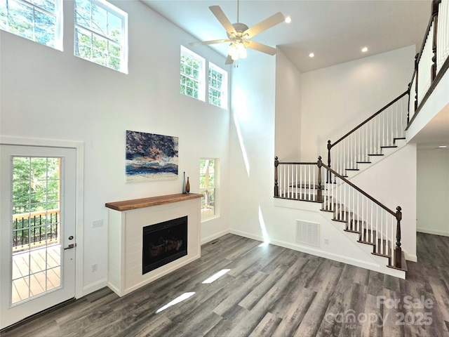 690 Settlers Trl, Mars Hill, NC 28754 - unfurnished living room with a high ceiling, wood finished floors, baseboards, stairway, and recessed lighting