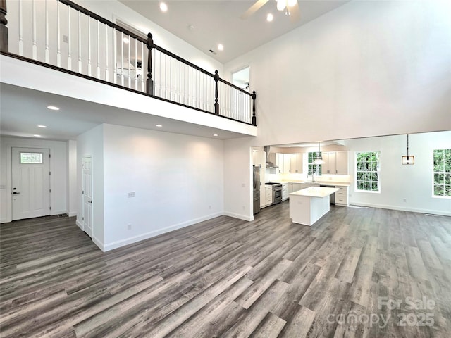 690 Settlers Trl, Mars Hill, NC 28754 - unfurnished living room with a towering ceiling, wood finished floors, ceiling fan, baseboards, and recessed lighting