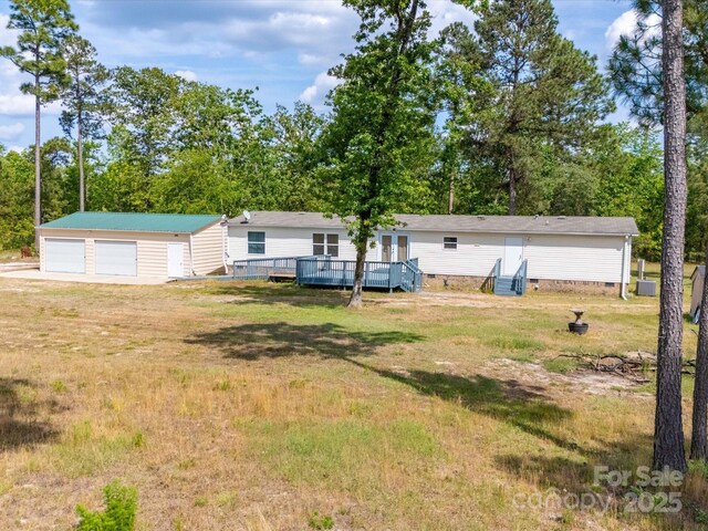2675 Andrews Cir, Aiken, SC 29803 - view of green lawn with a garage, an outbuilding, a deck, and view of scattered trees