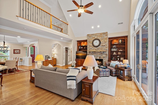 166 Pinnacle Shores Dr, Mooresville, NC 28117 - living area featuring high vaulted ceiling, arched walkways, a fireplace, ceiling fan, and light wood finished floors