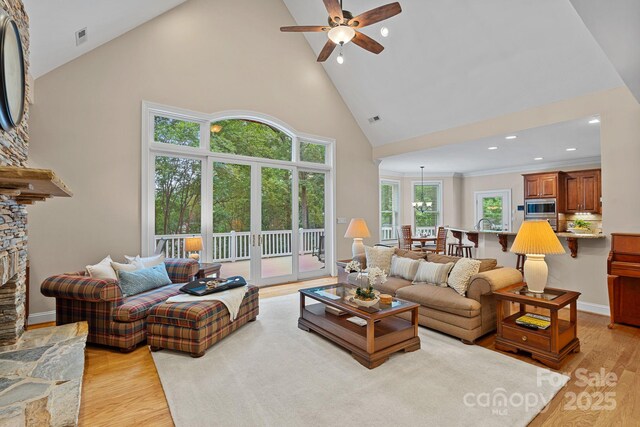 166 Pinnacle Shores Dr, Mooresville, NC 28117 - living area with high vaulted ceiling, light wood-style flooring, ceiling fan, a stone fireplace, and recessed lighting