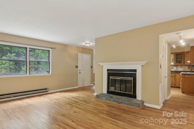 19 Reuben Branch Rd, Maggie Valley, NC 28751 - unfurnished living room with light wood finished floors, a glass covered fireplace, and baseboards