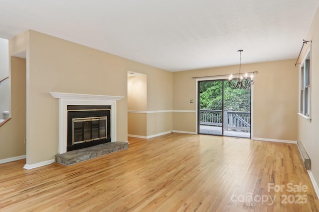 19 Reuben Branch Rd, Maggie Valley, NC 28751 - unfurnished living room with baseboards, wood finished floors, a chandelier, and a fireplace