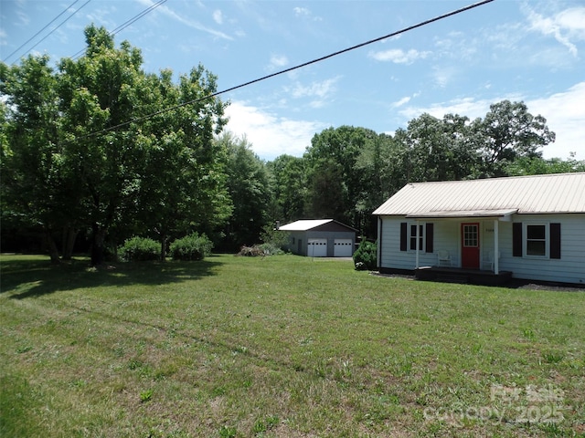 5004 King Wilkinson Rd, Denver, NC 28037 - view of green lawn with a detached garage, covered porch, and an outbuilding