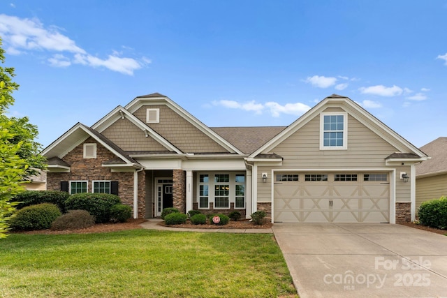 craftsman house with stone siding, driveway, a front yard, and a garage