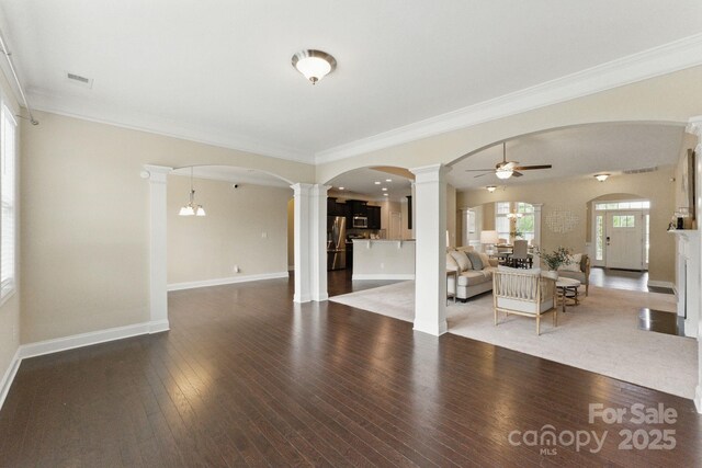 living room featuring decorative columns, ceiling fan, hardwood / wood-style floors, baseboards, and crown molding