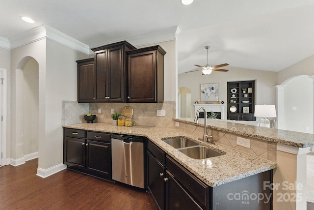 kitchen featuring dishwasher, a sink, arched walkways, a ceiling fan, and dark wood-type flooring