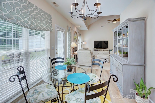 5748 Timbertop Ln, Charlotte, NC 28215 - dining room featuring lofted ceiling, ceiling fan, light wood-style flooring, and a chandelier