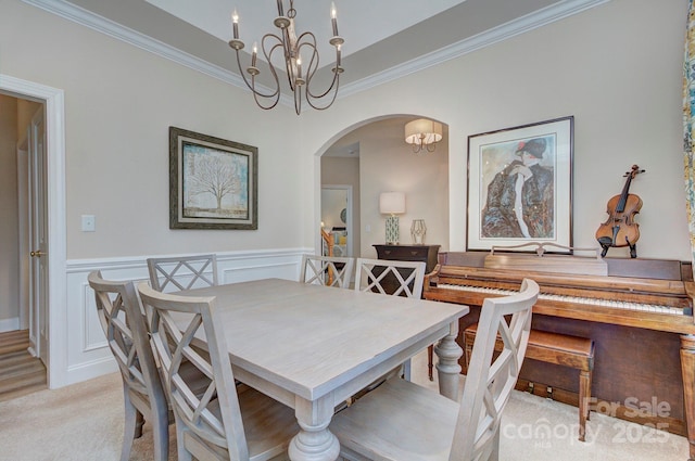 5748 Timbertop Ln, Charlotte, NC 28215 - dining area with arched walkways, a chandelier, crown molding, and a wainscoted wall
